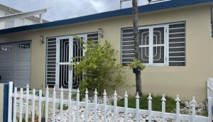 a white fence in front of a house at Apartamento con accesibilidad para ir a toda la isla in Bayamón