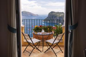 a balcony with a table with a view of the ocean at Hotel Caesar Augustus in Anacapri