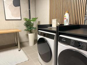 a kitchen with a washing machine and a counter at "FIVE" Premium Apartments Seekirchen - exklusive 4-Zi-Penthouse-Wohnung in Seekirchen am Wallersee