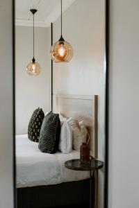 a bedroom with a bed with pillows and a table at Lighthouse Guesthouse & Cafe in Groblersdal