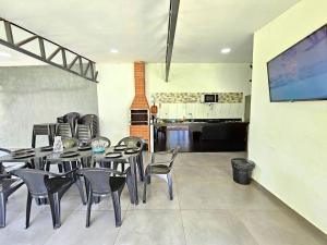 a dining room with a table and chairs and a television at Casa 2 quartos 2 banheiros em meio a Área Verde in Foz do Iguaçu