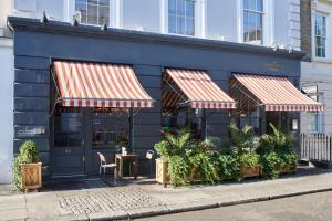 a restaurant with two awnings on the side of a building at Artist Residence London in London