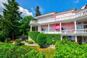 a pink house with ivy on the side of it at One-Bedroom Apartment in Crikvenica IX in Sopaljska