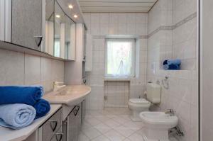 a white bathroom with a sink and a toilet at One-Bedroom Apartment in Crikvenica IX in Sopaljska +29 photos