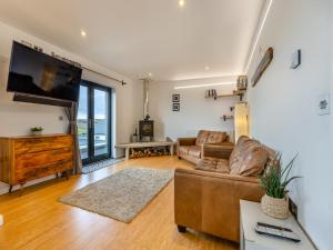 a living room with a couch and a flat screen tv at Tregarden in Poundstock