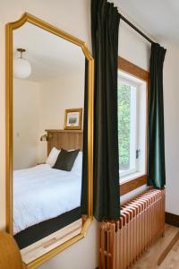 a bedroom with a mirror in front of a bed at Hôtel Château Cran Chaud Chicoutimi in Saguenay
