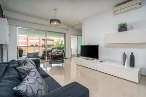 Una sala de estar con un sofá azul y un televisor. en FozPalace Residence SPA, en Portimão