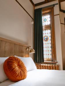 a bed with a wooden bowl on it with a window at Hôtel Château Cran Chaud Chicoutimi in Saguenay