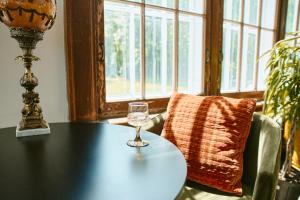 a table with a wine glass on top of it at Hôtel Château Cran Chaud in Saguenay