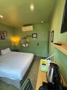 尼斯贝尔纳酒店的一间卧室配有一张床、一张桌子和茶壶