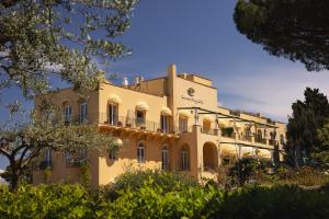 a large yellow building with trees in front of it at Hotel Caesar Augustus in Anacapri