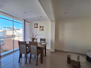 a dining room with a table and chairs and a window at Hidden Charm in Tasahuay