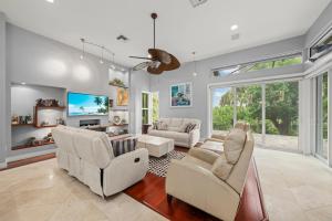 a living room with white furniture and a large window at Sanctuary Chateau in Sanibel