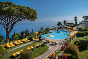 an image of a pool at a resort with chairs and umbrellas at Hotel Caesar Augustus in Anacapri