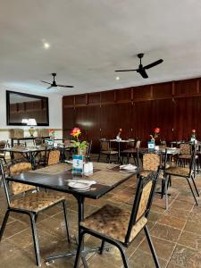 a dining room with tables and chairs and ceiling fans at The olive stay at Edwardian unit F7 in Port Edward