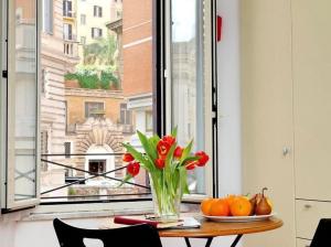 un vaso di fiori su un tavolo davanti a una finestra di 600mt To Colosseum a Roma