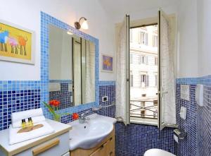 bagno piastrellato blu con lavandino e specchio di 600mt To Colosseum a Roma Altre 5 foto