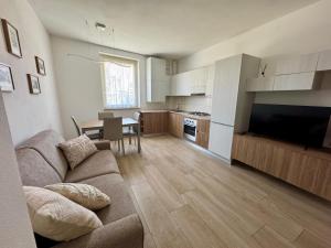 a living room with a couch and a table and a kitchen at Casa Pincio - Appartamento in centro con parcheggio privato - Central apartment with parking in Fano +8 photos