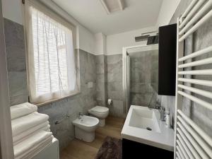 a bathroom with a white toilet and a sink at Casa Pincio - Appartamento in centro con parcheggio privato - Central apartment with parking in Fano