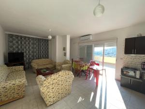 ein Wohnzimmer mit Sofa, Stühlen und einem Tisch in der Unterkunft Lilis Apartments Sea view in Sarandë