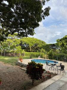 a patio with a table and chairs next to a pool at Finca el origen in Roldanillo