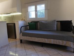 a bed in a room with a window and a kitchen at SPYROS STONE house in Preveza
