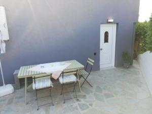 a patio with a table and chairs and a white door at SPYROS STONE house in Preveza