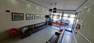 a living room with a leather couch and red chairs at Hotel Rio Branco in Aparecida +26 photos