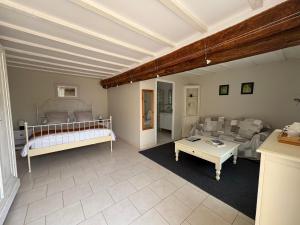 a living room with a bed and a couch at Les Peupliers Loire in Varennes-sur-Loire