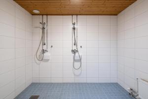 a shower in a white tiled bathroom at Hiisi Hostel Vihti - Private Rooms in Vihti +61 photos