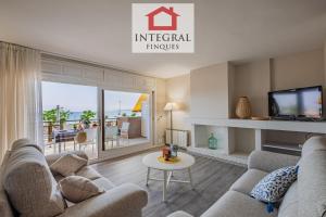 un soggiorno con un divano e una TV di Apartament del Zenit a Palamós