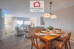 una sala da pranzo e un soggiorno con tavolo e sedie di Apartament del Zenit a Palamós