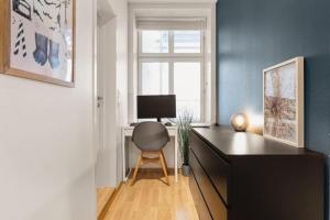 a desk with a computer and a chair in a room at Dinbnb Apartments I 500m to Bryggen in Bergen