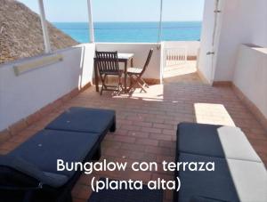a patio with a table and chairs and the ocean at Mandala Bungalows - Adults Only in Los Caños de Meca