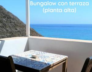 a table with a bowl on it on a balcony overlooking the ocean at Mandala Bungalows - Adults Only in Los Caños de Meca