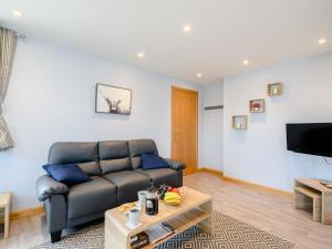 a living room with a couch and a table at Sand View in Mainsriddle