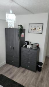 a black dresser and a cabinet in a room at Luxurious ensuite rooms in Basildon