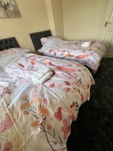 two beds sitting next to each other in a bedroom at Canal Way- Cozy 3-Bed House in Ilminster