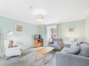 a living room with a couch and chairs and a table at The Low Crescent in Hawick