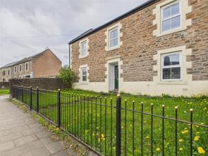 a black fence in front of a brick house at The Low Crescent in Hawick