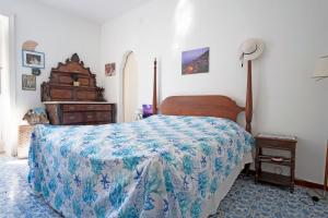 a bedroom with a bed with a blue and white bedspread at Elegant Capri Villa with Garden, Sea Access and Panoramic Terrace in Capri
