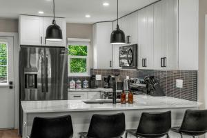 a kitchen with a refrigerator and some black chairs at Stylish Arvada Duplex Central Access to Denver in Arvada