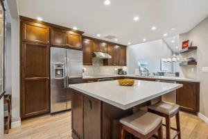 a kitchen with stainless steel appliances and wooden cabinets at Chic Palm Desert Gem - Relax, Swim, Repeat in Palm Desert