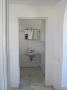 a white bathroom with a sink and a mirror at Tsanakou Vineyard Glinado in Glinado Naxos