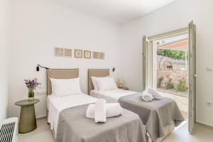 two beds in a room with a window at Villa Alma - Aliki Center in Aliki +13 photos