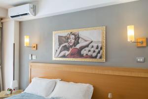 a painting above a bed in a hotel room at Catania Crossing B&B - Rooms & Comforts in Catania