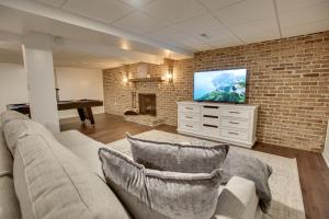 a living room with a couch and a flat screen tv at Zook Manor with Hot tub Firepit and Game Room in Atglen