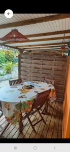 ein Tisch und ein Stuhl auf einem Deck in der Unterkunft KAZ HIBISCUS maison de vacances 1 chambre à 200m de la plage anse à l'âne 3 ILETS in Les Trois-Îlets