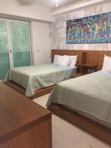 a bedroom with two beds and a painting on the wall at Hermoso condominio in Cancún +9 photos