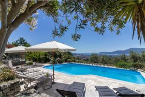 a swimming pool with chairs and an umbrella at Villa Amaranta in La Spezia